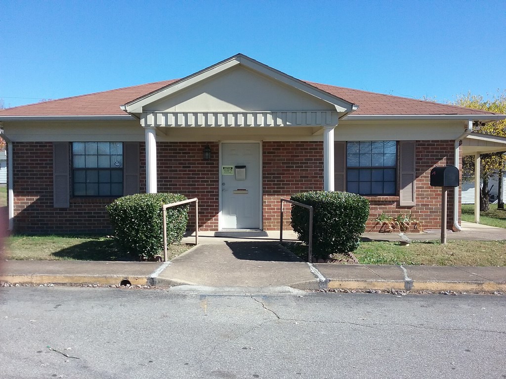 a small brick house with a white front door